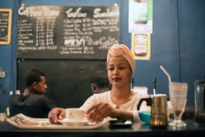 Sara serves coffee to a customer in Cup of Art cafe.