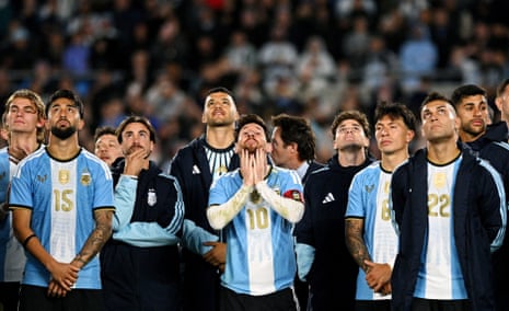 Lionel Messi presses his hands to his face, emotional, after his final international match
