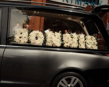 A floral arrangement spells out the singer’s name in the back of a hearse