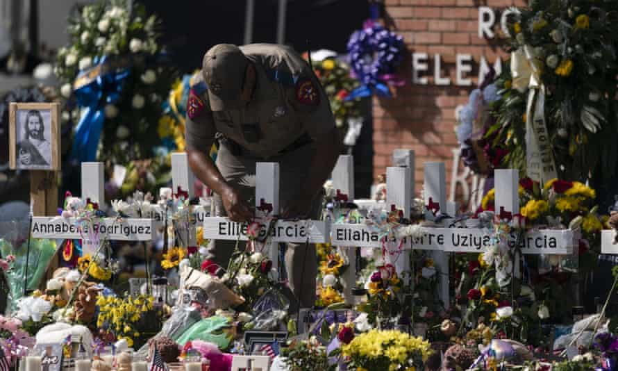 man leans over crosses with victims’ names