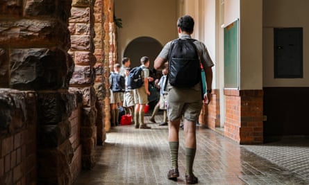 Schoolboys in short trousers walk down a corridor