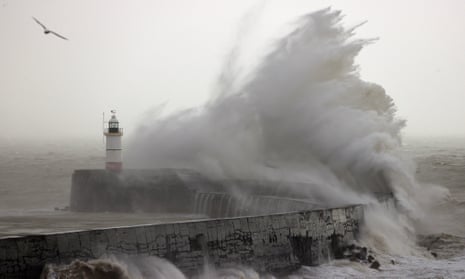 Waves crash over a lighthouse
