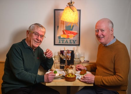 Two men facing each other across a restaurant table