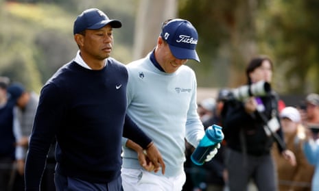Tiger Woods hands his playing partner Justin Thomas (right) a tampon