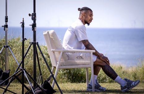 Juninho Bacuna of Curaçao on a chair with the sea in the distance