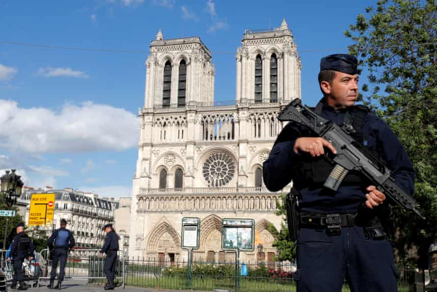 French police and gendarmes stand at the scene of a shooting incident near the Notre Dame Cathedral in Paris.