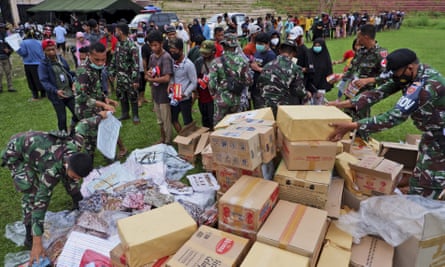 Indonesian soldiers distribute relief goods for those affected by the earthquake at a stadium in Mamuju, West Sulawesi, Indonesia.