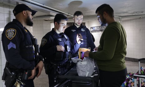 three officers look at man's bag using a flashlight