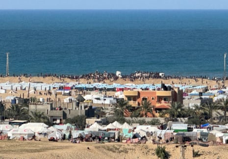 Palestinians gather around aid trucks driving through the beach road in Rafah on Thursday, amid the continuing conflict between Israel and Hamas.
