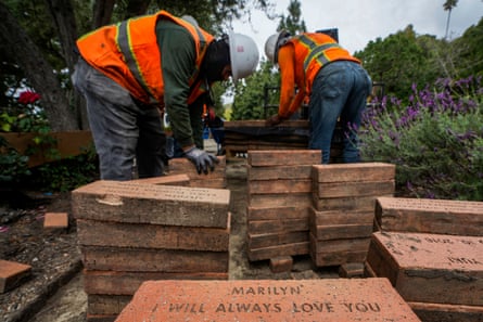 Workers remove bricks stamped with past members’ names from a garden path at Wayfarers Chapel in May.