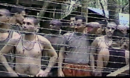 Colombian police and soldiers captured by Farc rebels press against a fence where they are being held at an encampment on 6 October 2000.