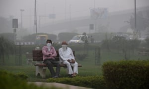 Two men cover faces in polluted New Delhi