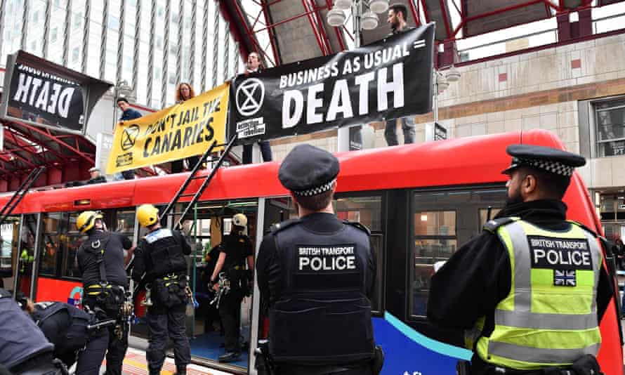 Police preparing to remove climate change activists on the roof of a DLR train at Canary Wharf station on Thursday.