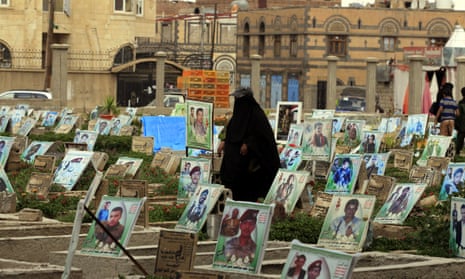 A Yemeni woman walks amongst portraits on the graves of Houthi militia members allegedly killed in fighting in the war-torn Arab country, at a cemetery in Sana’a.