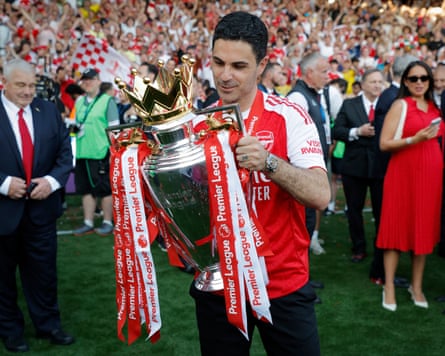 Mikel Arteta, the Arsenal manager, holds the Premier League trophy during his team's title winning celebrations.