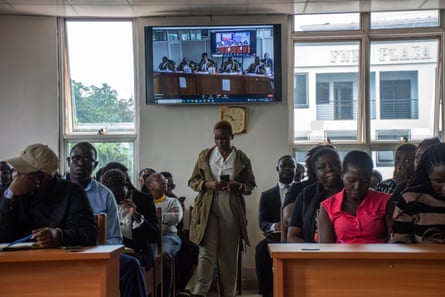 People sit at benches in a court room