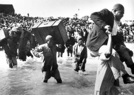 Palestinian refugees struggle across a river  in the exodus of 1948, known in Arabic as the Nakba (‘catastrophe’), when more than 700,000 Palestinian Arabs were expelled from their homes     