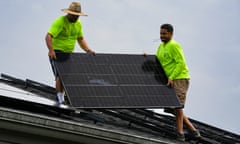 Workers install a solar panel on the roof of a home in Kentucky