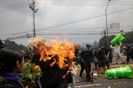 A person catches fire during clashes between protesters and the police before the opening ceremony.