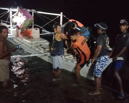 A survivor is assisted as he gets off a small boat after being rescued from the burning ferry A survivor is assisted as he gets off a small boat after being rescued from the burning ferry