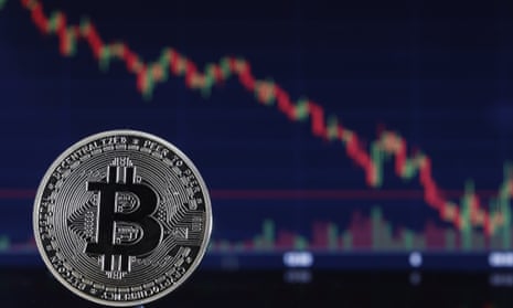a bitcoin 'coin' and a graph showing a long steady fall