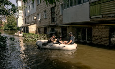 Volunteers evacuate an apartment building on a flooded street in Kherson, Ukraine.