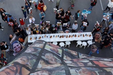 Friends, family members and supporters of hostages kidnapped on the 7 October Hamas attack on Israel stand near a table in Tel Aviv with a Shabbat meal, during a protest calling for the release of the hostages from Gaza on Friday.