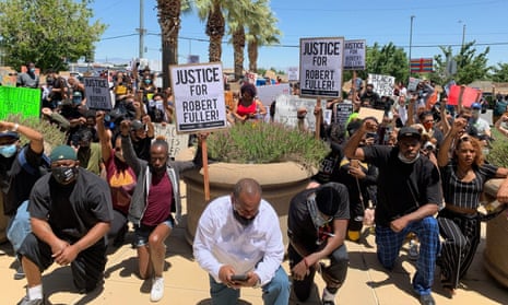 Protesters kneel in front of the Palmdale sheriff’s station to demand an investigation into the death of Robert Fuller.