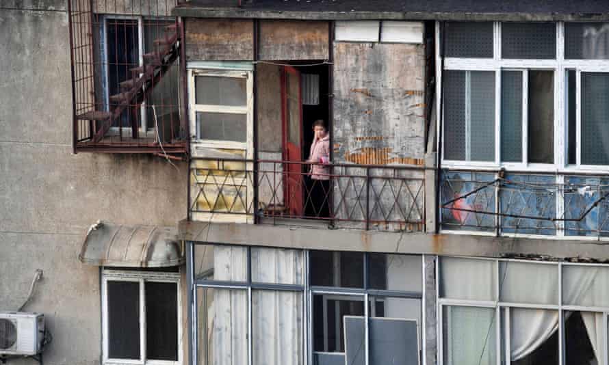 woman looks outside from the balcony at a residential compound in Wuhan, the centre of the novel coronavirus outbreak
