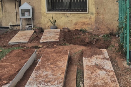 A dug-up grave behind other graves.