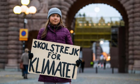 Greta Thunberg poses for a photo with a sign reading ‘School strike for climate’ as she protests in front of the Swedish parliament in November. 
