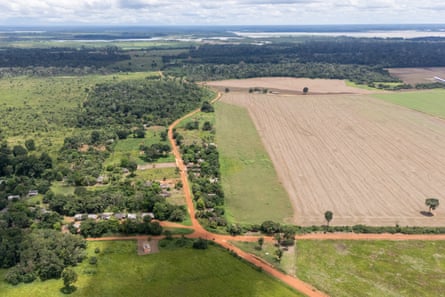 A view of a small village and areas of forest alongside huge fields.