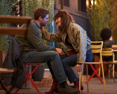 Luke (Jay Duffy) and Rachel (Caroline Menton) sitting on chairs outside a pub
