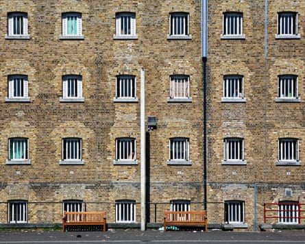 A Victorian building with lots of small windows with bars on them.
