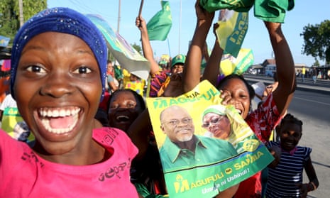 A Tanzanian supporter holds a poster featuring the newly elected president John Magufuli. 