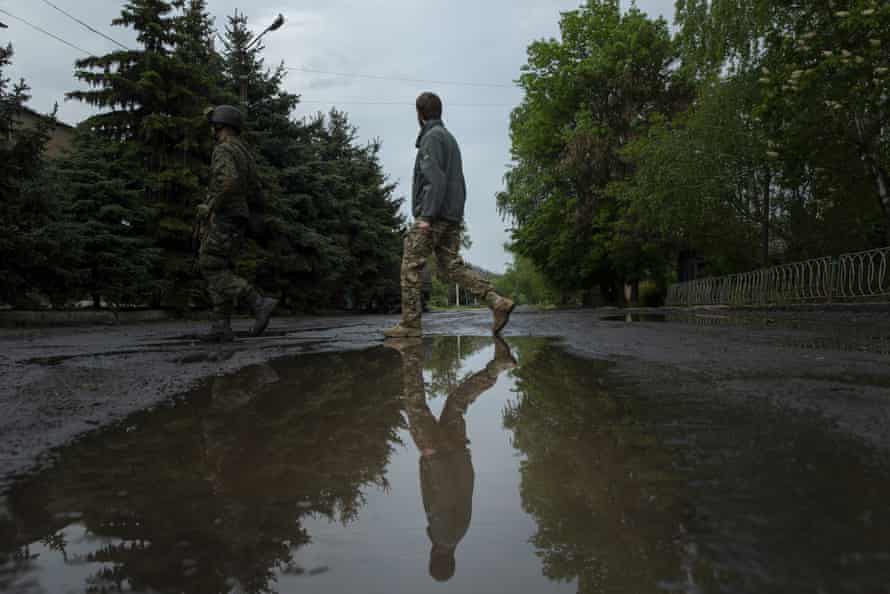 From left, veteran soldier Aaron and new recruit Yost walk across a street while exploring areas damaged during the Russian invasion at Barvinkove.