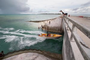 Children playing chicken with the passing boats on the Nippon causeway that joins Betio with the rest of South Tarawa.