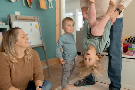 Two kids play with their parents in a playroom