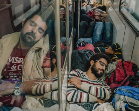 Somar and his companions sleep while crammed into a corridor and compartments on a train headed to Serbia.