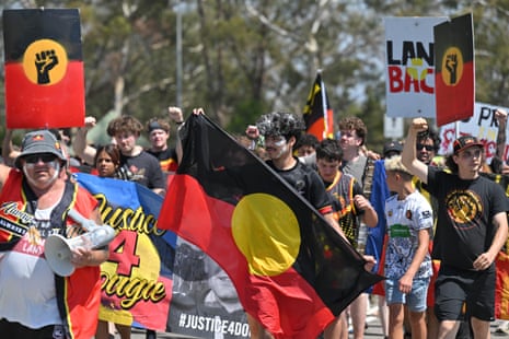 Protesters march past Parliament House in Canberra