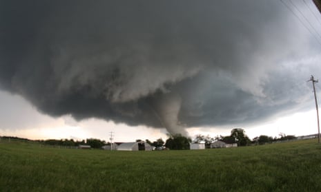 A tornado roars across farmland close to farm buildings in Katie, Oklahoma, USA
