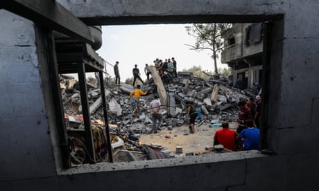 Rescuers check the rubble of a house in Rafah destroyed by an Israeli airstrike
