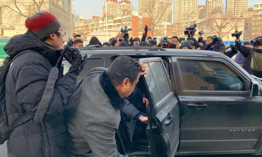 Activist Yang Chunlin is bundled into a car by authorities after protesting outside Wang Quanzhang’s trial.