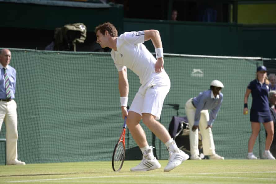 Andy Murray grimaces as he holds his hip at Wimbledon in 2013.