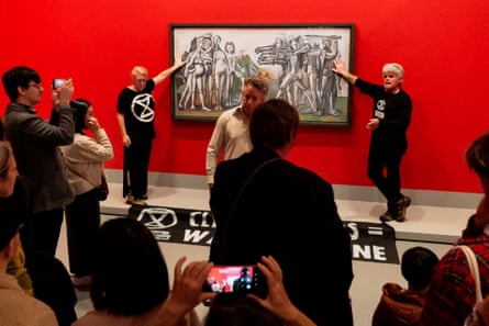 Extinction Rebellion climate activists with their hands glued to the perspex covering of Picasso’s anti-war painting Massacre in Korea at the National Gallery of Victoria in Melbourne on 9 October.