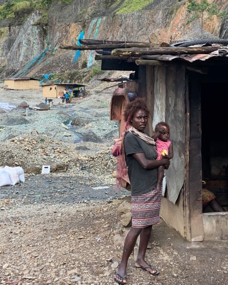 Families live in the disused mine pit at Panguna, attempting to make a living from alluvial mining. Polluted, unnaturally blue water, contaminates the pit and there are frequent landslides.