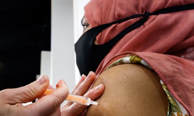 A woman receives a dose of the Oxford/AstraZeneca coronavirus vaccine at Elland Road vaccine centre in Leeds.