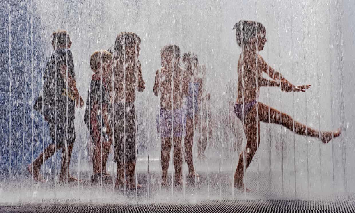 Children play in the fountains outside the Hayward Gallery on the South Bank, London, enjoying the hot, sunny weather. Commissioned