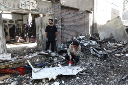 People next to the bombed wreckage of a building