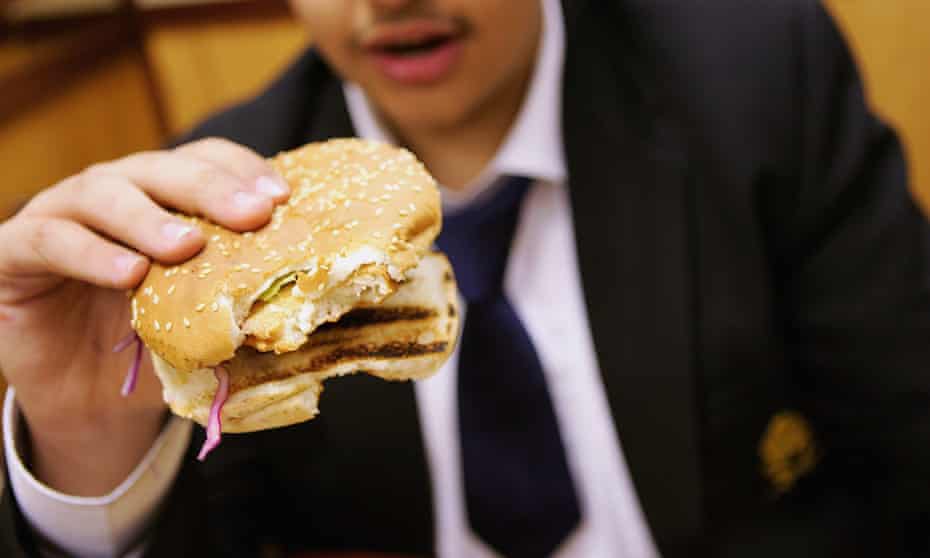 Schoolboy eating chicken burger